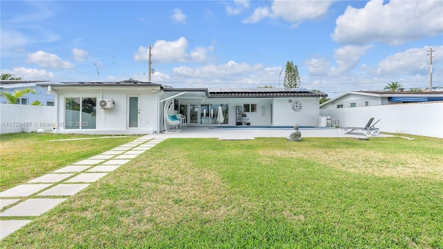 back of property with a lawn, solar panels, and a patio