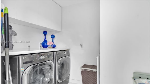 clothes washing area featuring cabinets and separate washer and dryer