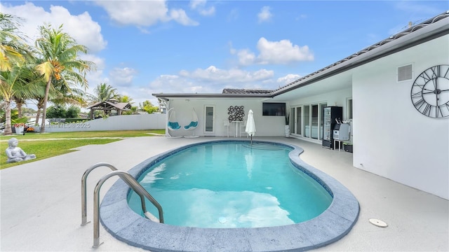 view of swimming pool with a patio area and a yard