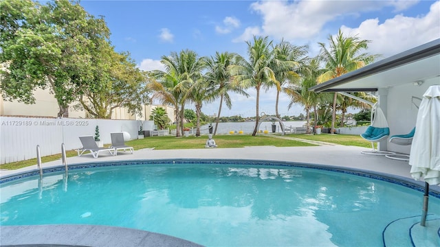 view of swimming pool with a yard