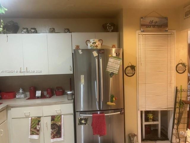 kitchen with white cabinets and stainless steel fridge