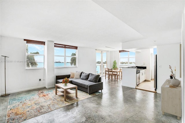 living room featuring concrete floors and a water view