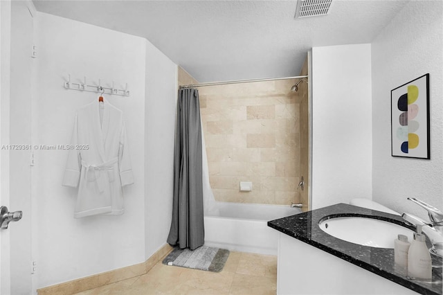 bathroom with tile patterned floors, shower / tub combo, a textured ceiling, and vanity