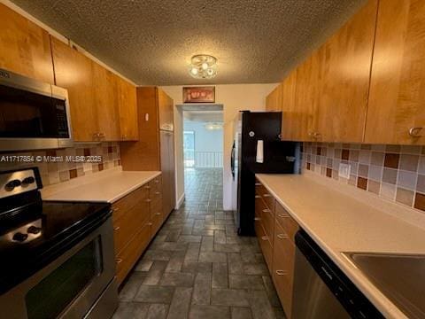 kitchen featuring backsplash, stainless steel appliances, and a textured ceiling