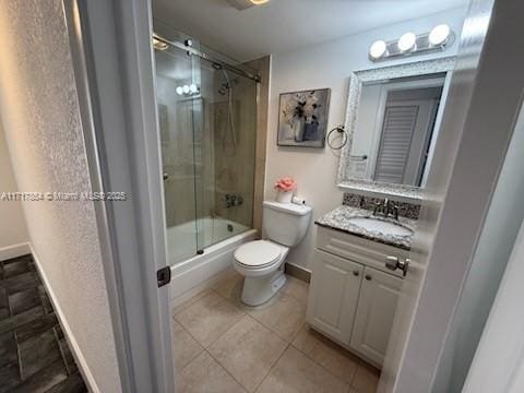 full bathroom with toilet, vanity, tile patterned floors, and shower / bath combination with glass door