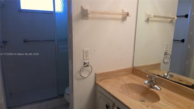 bathroom with vanity, toilet, and a shower with door