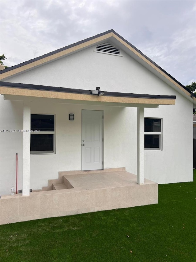 back of property with a patio area and a lawn