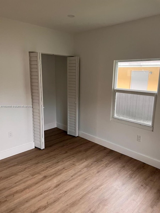 unfurnished bedroom featuring a closet and light hardwood / wood-style flooring