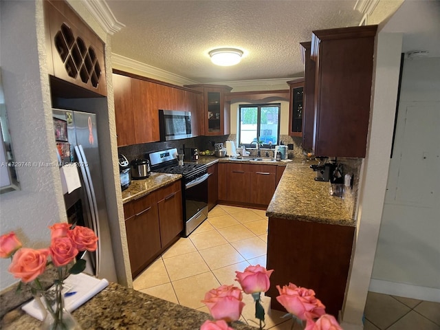 kitchen featuring sink, stainless steel appliances, crown molding, and light tile patterned floors