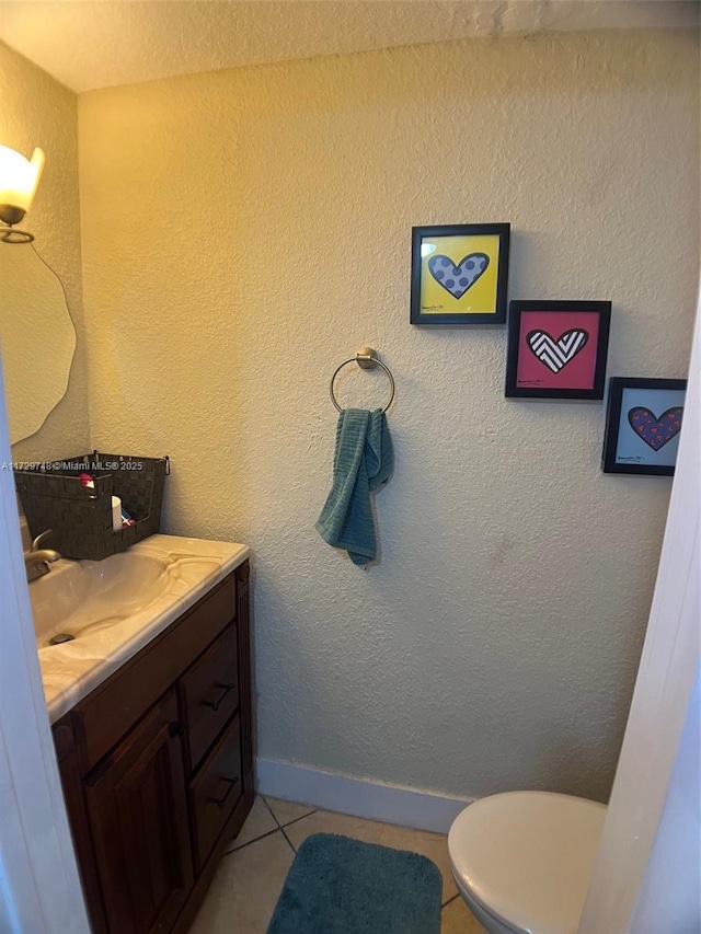 bathroom with toilet, tile patterned floors, and vanity