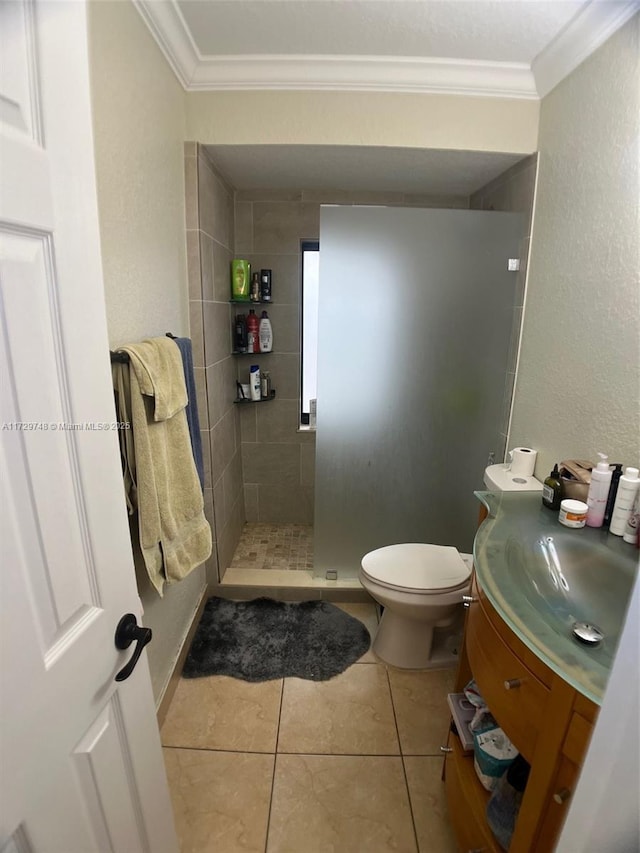 bathroom with ornamental molding, tiled shower, tile patterned flooring, and vanity