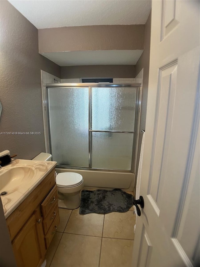 full bathroom featuring toilet, vanity, shower / bath combination with glass door, and tile patterned flooring