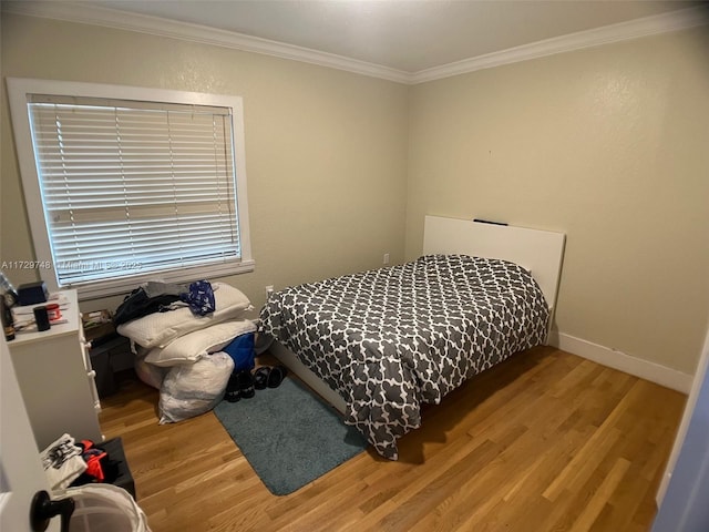 bedroom with hardwood / wood-style flooring and ornamental molding