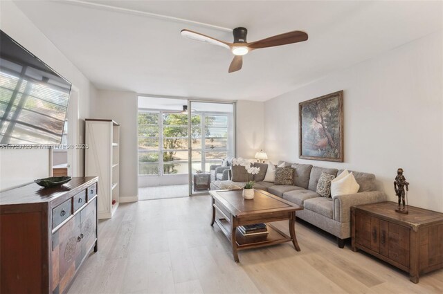 living room featuring ceiling fan, expansive windows, and light hardwood / wood-style floors