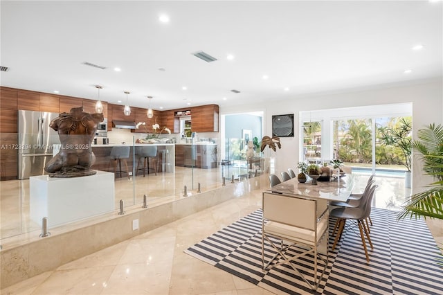 dining room with light tile patterned floors and crown molding