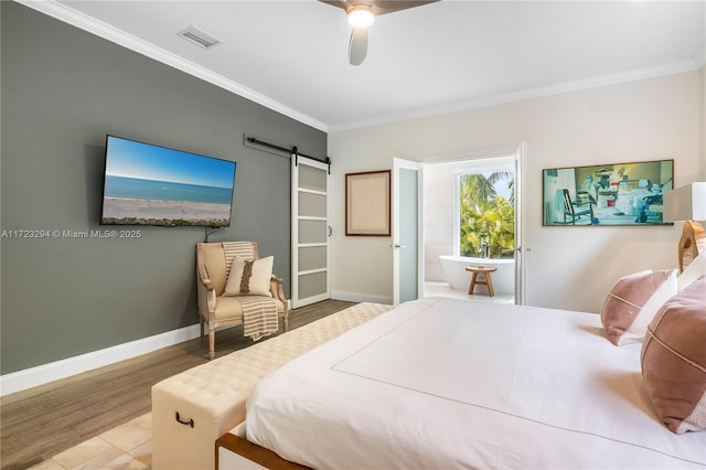 bedroom with ceiling fan, a barn door, hardwood / wood-style floors, and crown molding