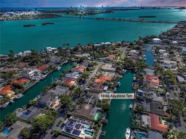 aerial view at dusk featuring a water view