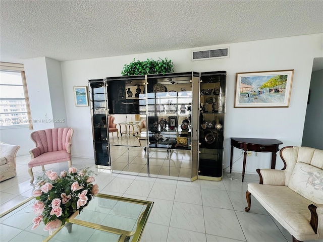 living room featuring a textured ceiling and tile patterned flooring