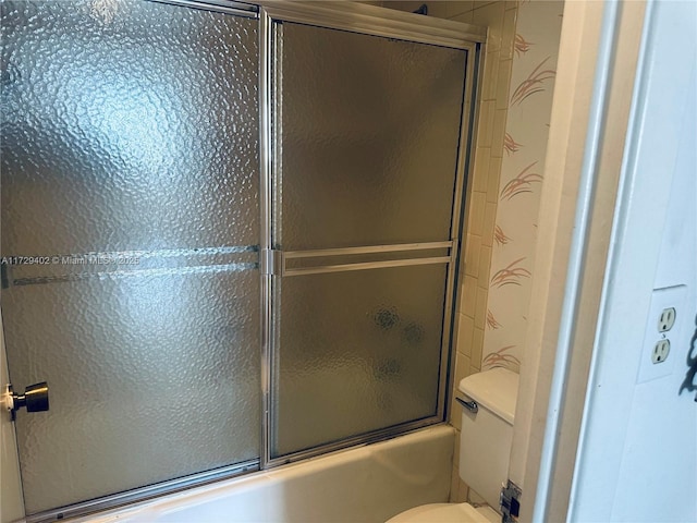 bathroom featuring shower / bath combination with glass door and toilet