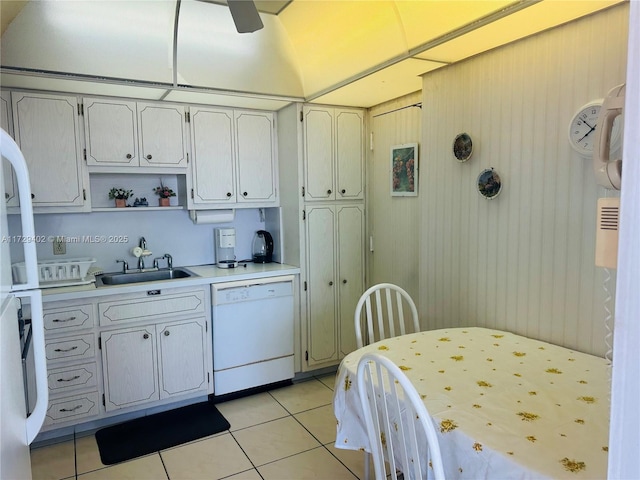 kitchen with white dishwasher, sink, and light tile patterned floors