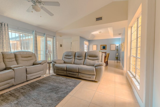 living room with vaulted ceiling, ceiling fan, and light tile patterned floors