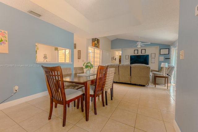 dining space with vaulted ceiling, ceiling fan, and light tile patterned floors