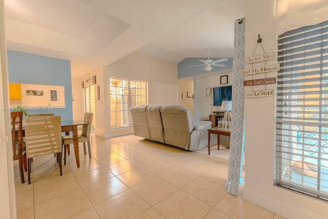 living room with ceiling fan, light tile patterned floors, and vaulted ceiling