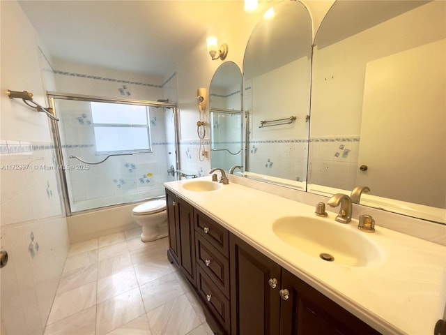 full bathroom featuring enclosed tub / shower combo, tile patterned flooring, vanity, tile walls, and toilet