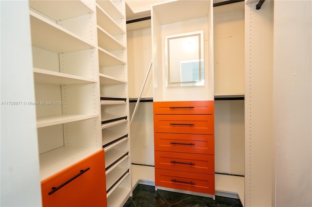 spacious closet with dark tile patterned flooring