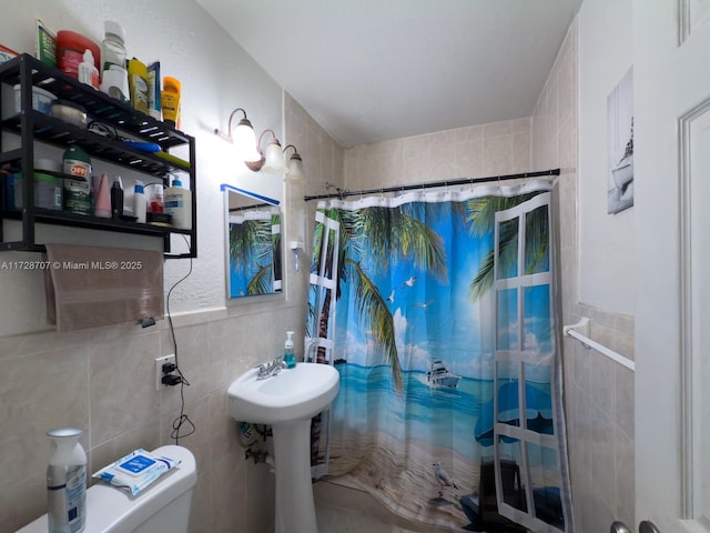 bathroom with a shower with curtain, toilet, and tile walls