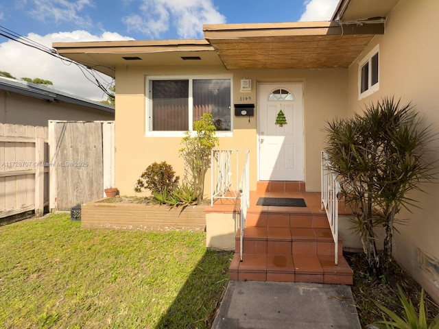 property entrance featuring a lawn