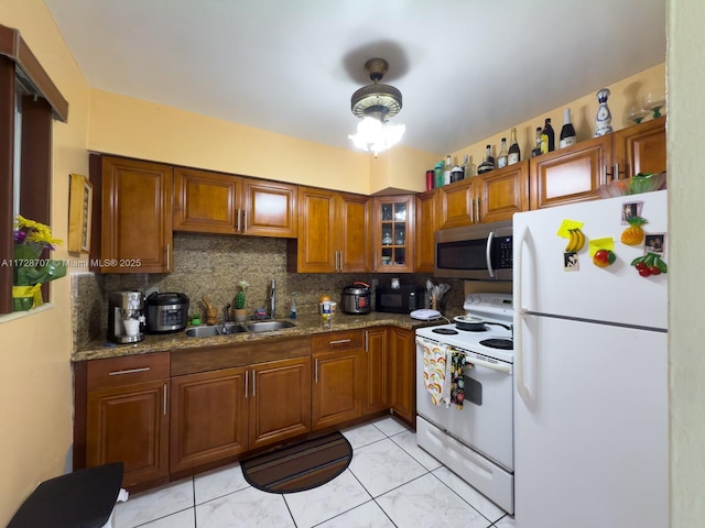 kitchen featuring stone countertops, sink, tasteful backsplash, light tile patterned floors, and white appliances