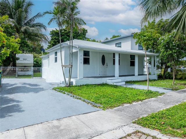 713 SW 7th St, Dania Beach, FL 33004 - view of front of house featuring stucco siding, covered porch, and driveway