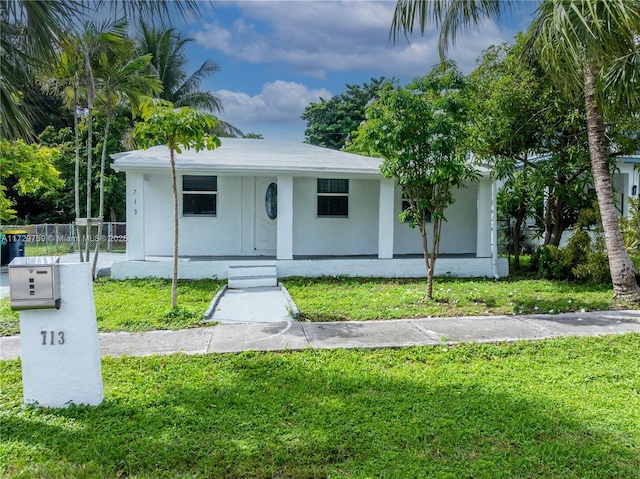 view of front of home with covered porch and a front lawn