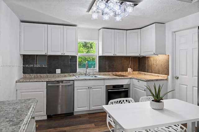 kitchen with dark hardwood / wood-style floors, white cabinetry, sink, decorative backsplash, and stainless steel appliances