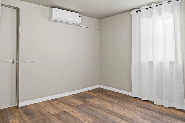 unfurnished room featuring dark hardwood / wood-style flooring and an AC wall unit