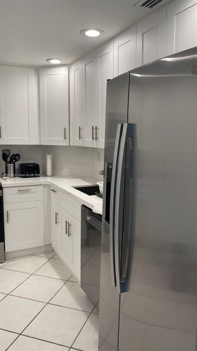 kitchen featuring stainless steel refrigerator with ice dispenser, white cabinetry, black dishwasher, and light tile patterned floors