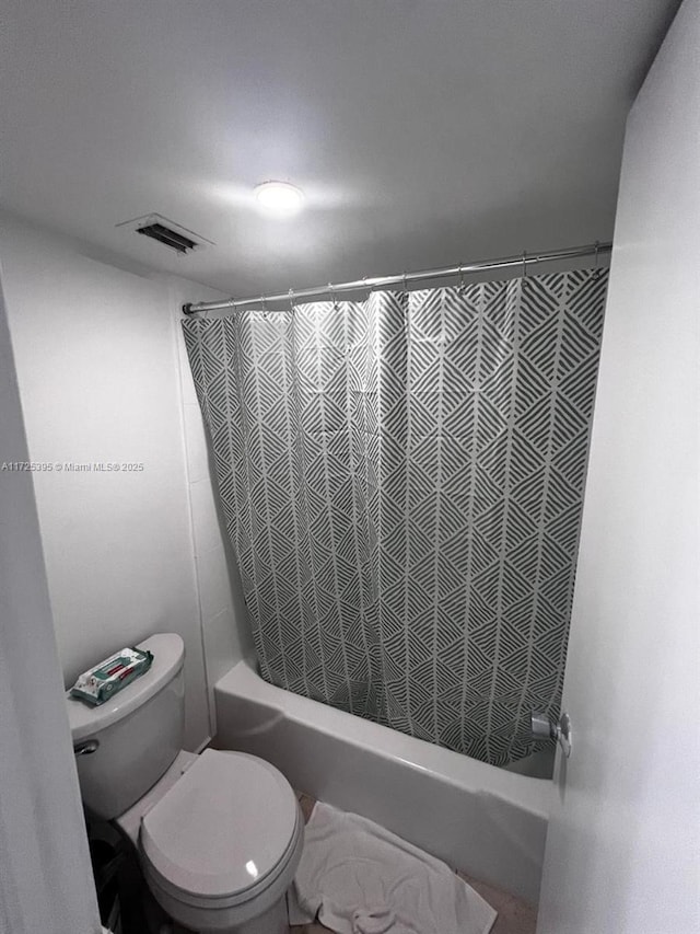 bathroom featuring toilet and shower / tub combo