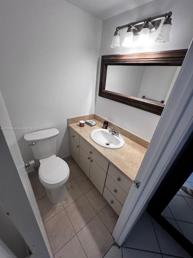 bathroom featuring tile patterned flooring, vanity, and toilet