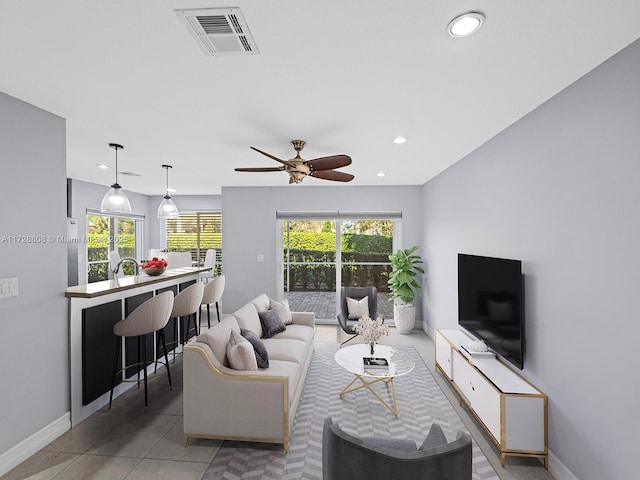 tiled living room with ceiling fan