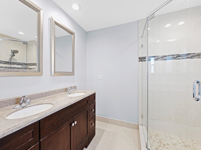 bathroom featuring a shower with shower door and vanity