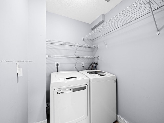 washroom featuring a textured ceiling and independent washer and dryer