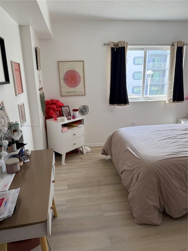 bedroom featuring a textured ceiling and light wood-type flooring