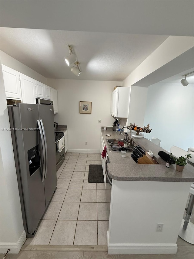 kitchen featuring kitchen peninsula, sink, white cabinets, light tile patterned floors, and stainless steel appliances