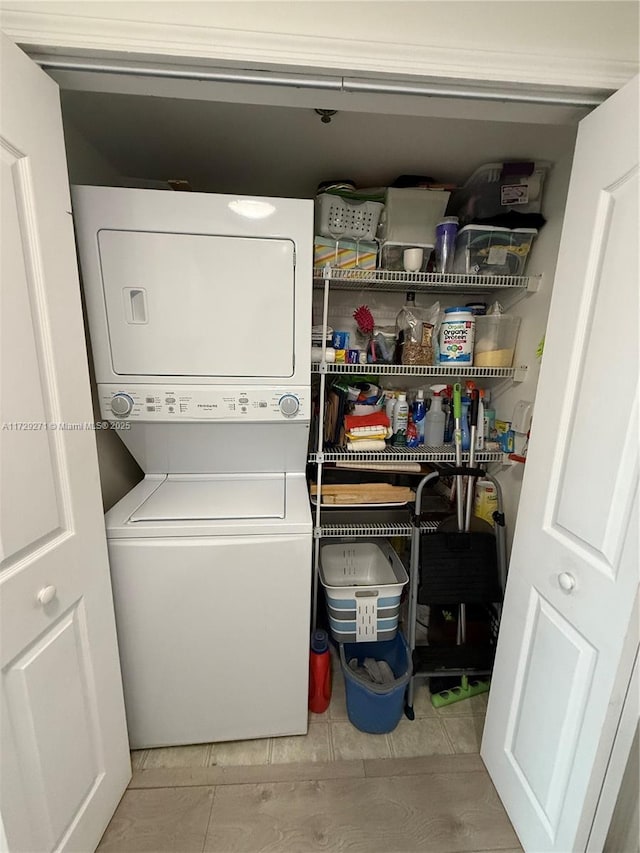 clothes washing area with stacked washer / dryer