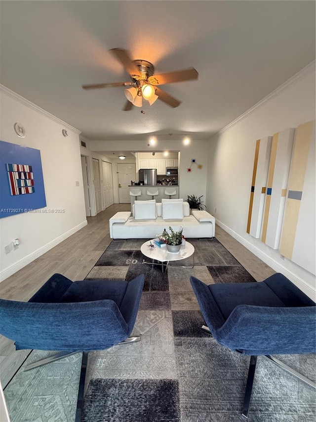 living room featuring dark wood-type flooring, ceiling fan, and ornamental molding