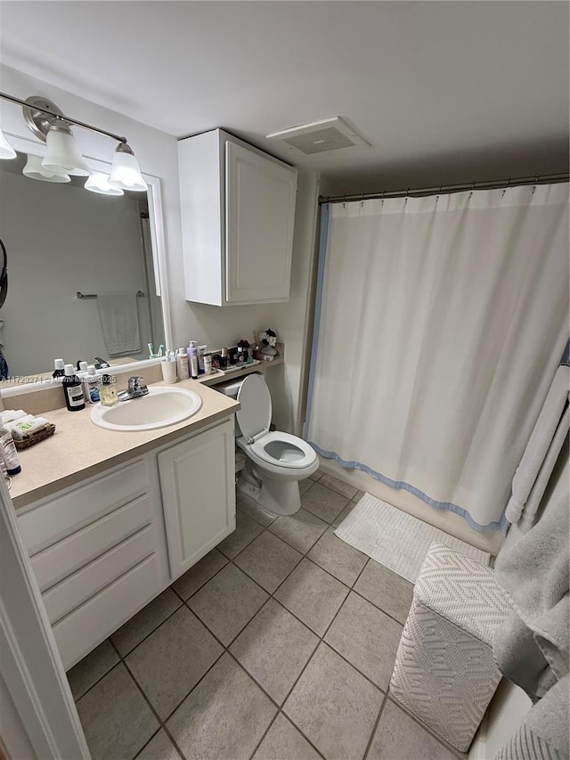 bathroom featuring tile patterned floors, vanity, toilet, and walk in shower