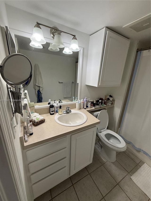 bathroom with toilet, tile patterned floors, and vanity