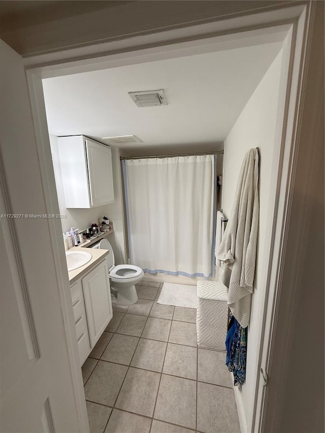 bathroom featuring curtained shower, toilet, tile patterned floors, and vanity