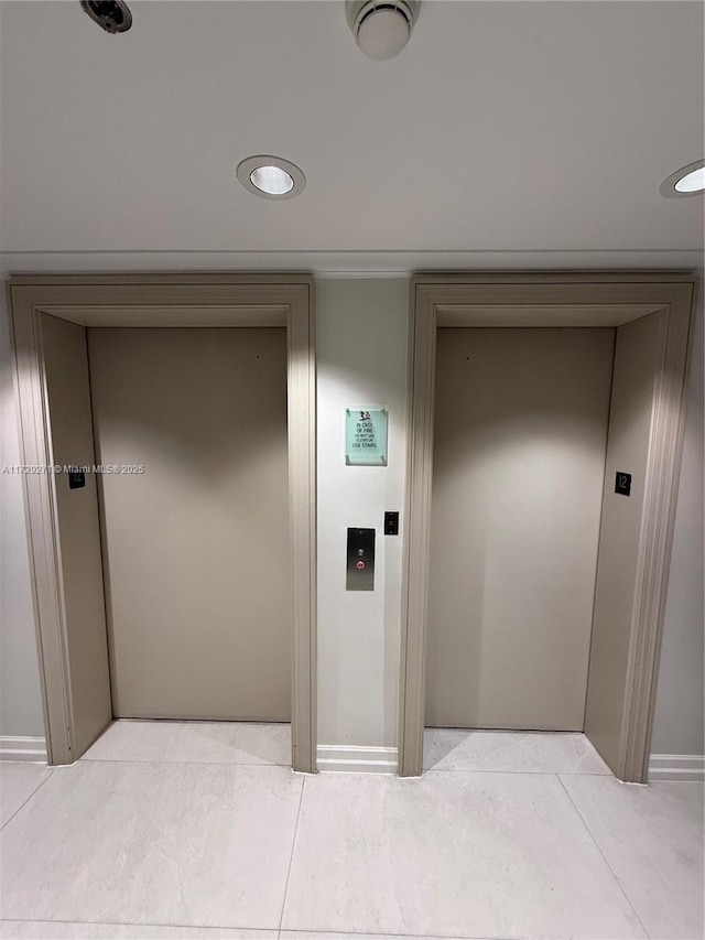 hall featuring elevator and light tile patterned floors